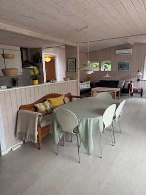 A cozy interior with a dining area, a sofa, and a kitchen. - Forest retreat near beach and Rønne (Rønne)