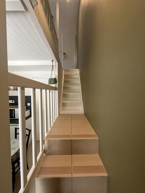 A narrow hallway with a wooden staircase leading to a second floor. - Ty Heol - BRECH - Vacation Rental (BRECH)