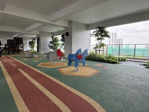 Un espace de jeux pour enfants avec des équipements colorés et une piste de course.