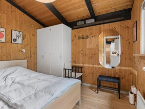 A bedroom with a bed, a wardrobe, a bench, a mirror, and a radiator. - "Erich" - 500m from the sea by Interhome (Aakirkeby)