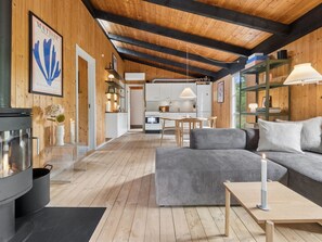 A cozy interior with a fireplace, a sofa, a dining area, and a kitchen. - "Erich" - 500m from the sea by Interhome (Aakirkeby)
