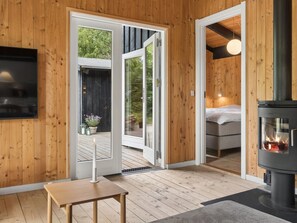 Ein Holzinnenraum mit Kamin, einem Bett und einem Fernseher.