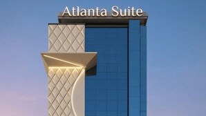 Een gebouw met een bord waarop 'Atlanta Suite' staat en een opvallend architectonisch kenmerk dat op een kruis lijkt.
