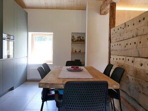 Ein Essbereich mit einem Holztisch, Stühlen und einem Fenster.