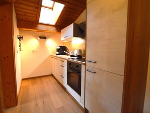 A compact kitchen with a skylight, a coffee maker, and a stove. - Charming and comfortable apartment (Wald im Pinzgau)