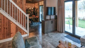 Ein modernes Interieur mit einer Holztreppe, einem Essbereich, einer Küche und einer Sitzecke mit Couchtisch.