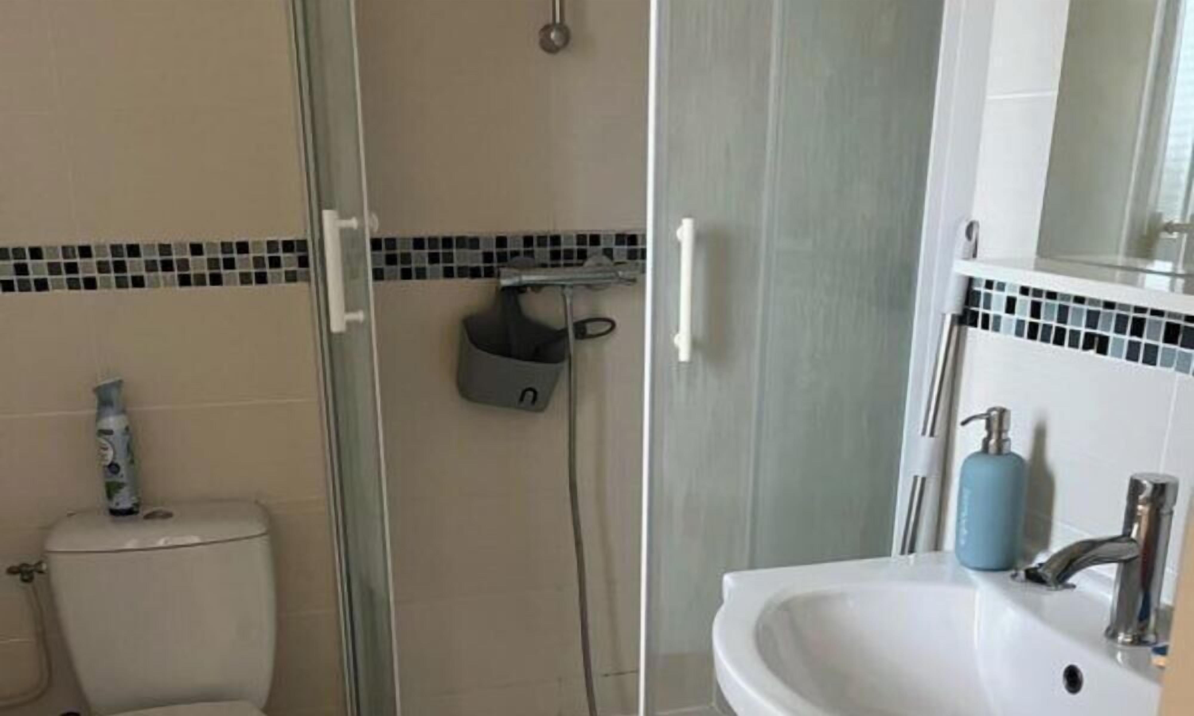 A bathroom with a shower, toilet, and sink.