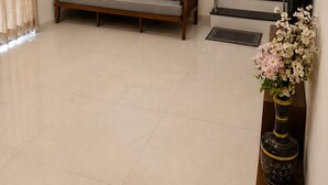 Ein modernes Wohnzimmer mit einer Couch, einer Treppe und einer dekorativen Vase.
