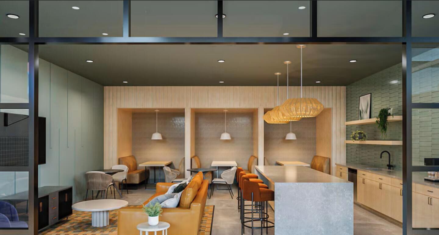 Un interior moderno con una zona de bar, asientos y una cocina visible a través de separaciones de vidrio.