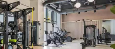 A gym with various exercise equipment, including weight machines and cardio machines.