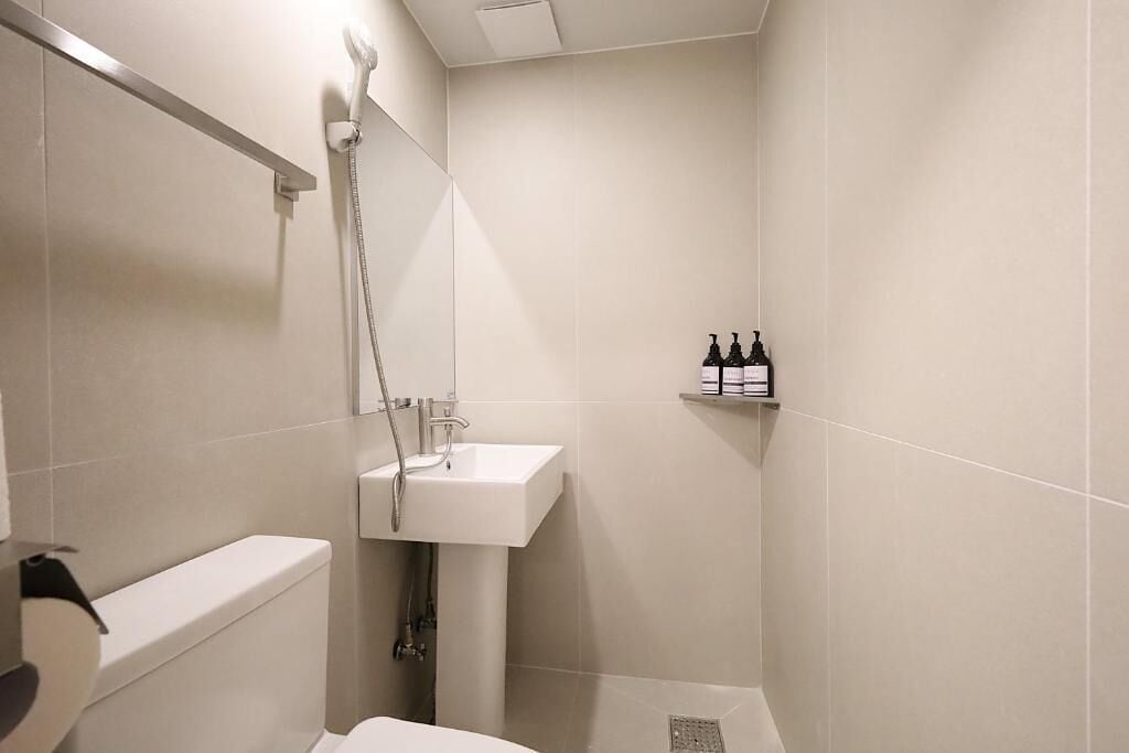 Ein kleines, modernes Badezimmer mit Toilette, Waschbecken und Dusche.