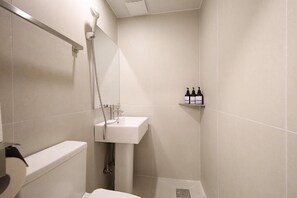 A small, modern bathroom with a toilet, sink, and shower. - Sunsu Hotel Mia (Seoul)