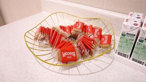 Una encimera de cocina con una cesta de alambre que contiene galletas empaquetadas.