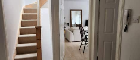 A staircase leading to a living area with a sofa and a chair.