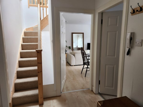 A staircase leading to a living area with a sofa and a chair.