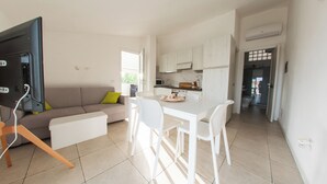 A modern apartment with a living room, dining area, and kitchen. - Huge Terrace Sea Front (Bosa Marina)