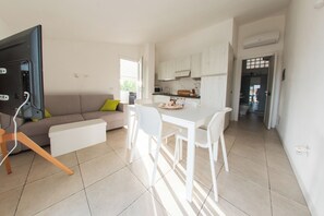 Ein modernes Apartment mit Wohnzimmer, Essbereich und Küche.