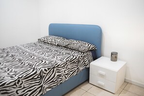 Ein Schlafzimmer mit einem Bett, einem Nachttisch und einer Kommode.