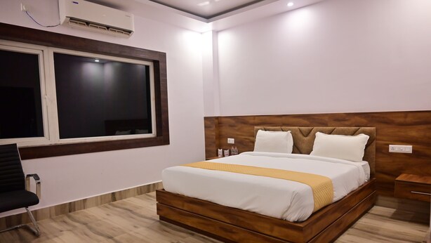 Habitación de hotel con una cama grande, una ventana, un escritorio y una silla.