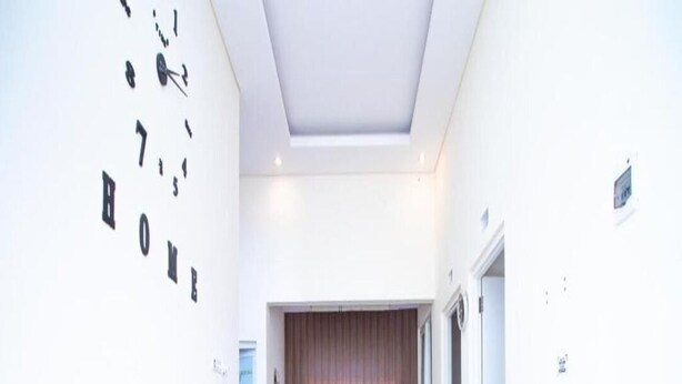 A modern living room with a sofa set, a flat-screen TV, and a fan. - Cozzy Villa Azzalia (batu)