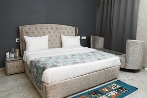 A bedroom with a bed, bedside tables, a chair, and a rug. - Rajaji Forest Castle - RFC by Rosalie (Ganga Bhogpur Talla)
