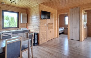 A modern log cabin interior with a kitchen, dining area, and a bedroom. - Nice home in Darlowo with sauna (Darlowo)