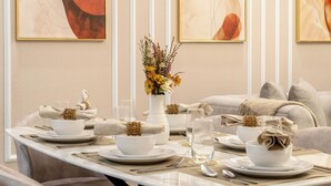 Uma sala de jantar com uma mesa posta para quatro pessoas, incluindo tigelas, pratos, talheres e copos.