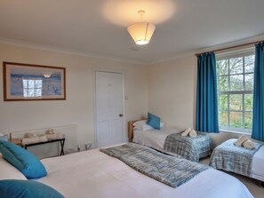 A hotel room with a bed, a radiator, a painting, and a window with curtains. - St Davids Meadow House (Woodford)