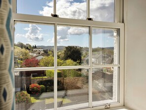 Ein Fenster mit Blick auf eine Wohngegend, einschließlich Häuser und Grünflächen.
