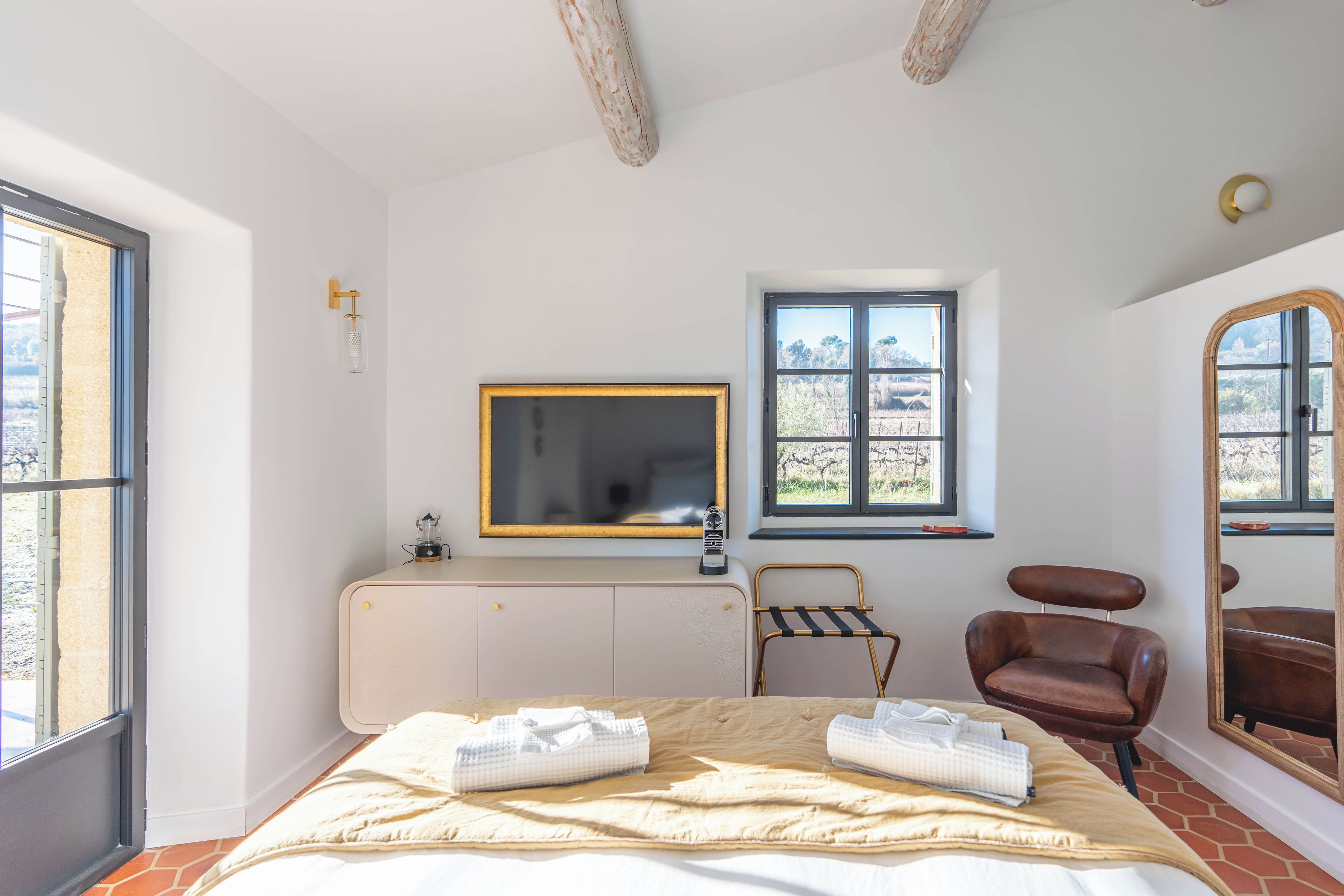Une chambre à coucher avec un lit, une chaise, une fenêtre et un radiateur.