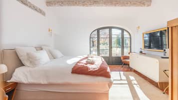 Un dormitorio con cama, ventana, silla y radiador.