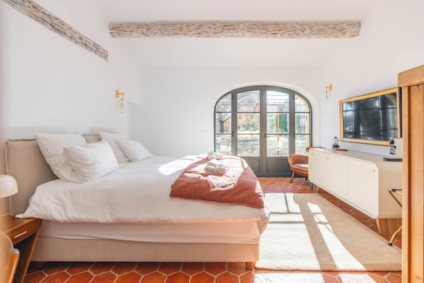 A bedroom with a bed, a window, a chair, and a radiator.