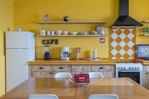 A kitchen with a wooden countertop, a coffee machine, a blender, and a stove. - GuestReady - Casa Bela Vista (Ponta Garça)