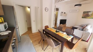 Comedor con una mesa, sillas y un televisor al fondo.