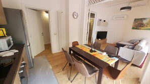 A dining area with a table, chairs, and a television in the background. - Il Fiorino di Santa Croce, 5 minutes from Santa Croce (Firenze)