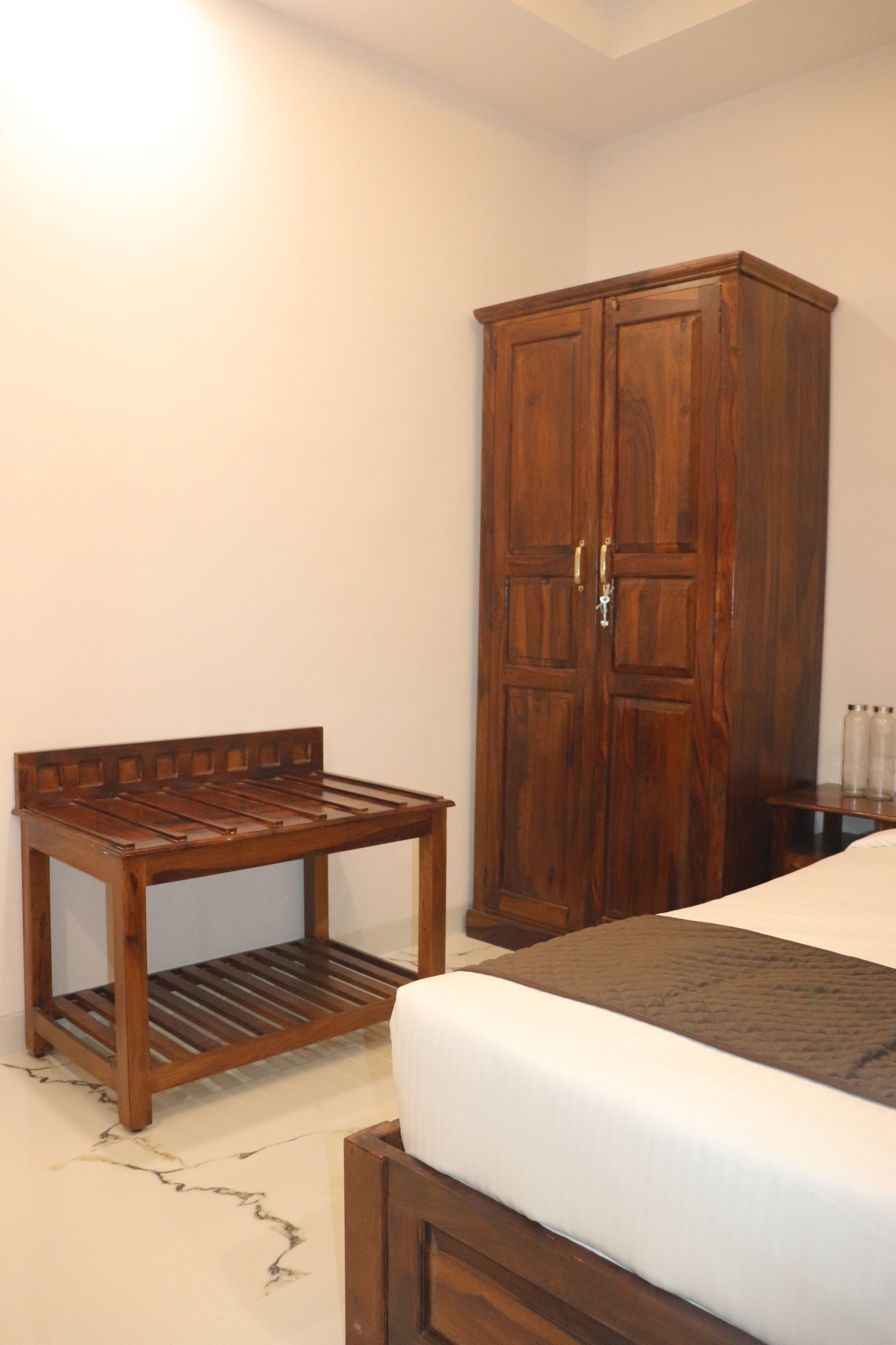 A bedroom with a wooden bed, a wooden nightstand, and a wooden wardrobe.