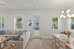 Uma sala de estar moderna com sofá, mesa de centro e área de jantar.
