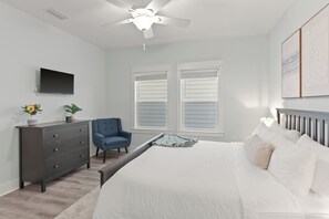 A bedroom with a bed, a dresser, a chair, a TV, and a ceiling fan. - Golf Cart + Community Pool + Game Room | Steps to Beach | Serene on 30A (Santa Rosa Beach)