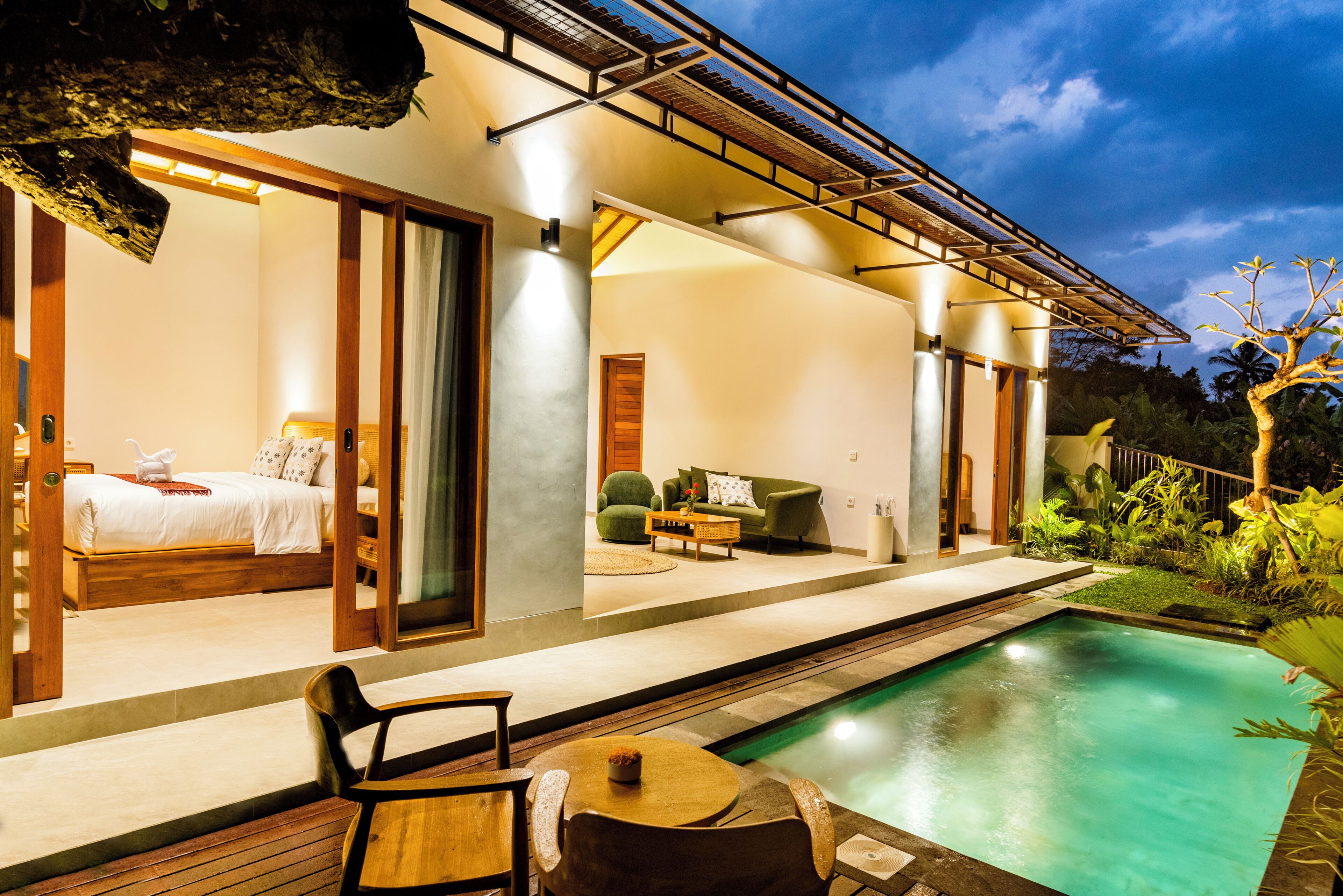 A modern outdoor living area with a pool, a bed, and a seating area.