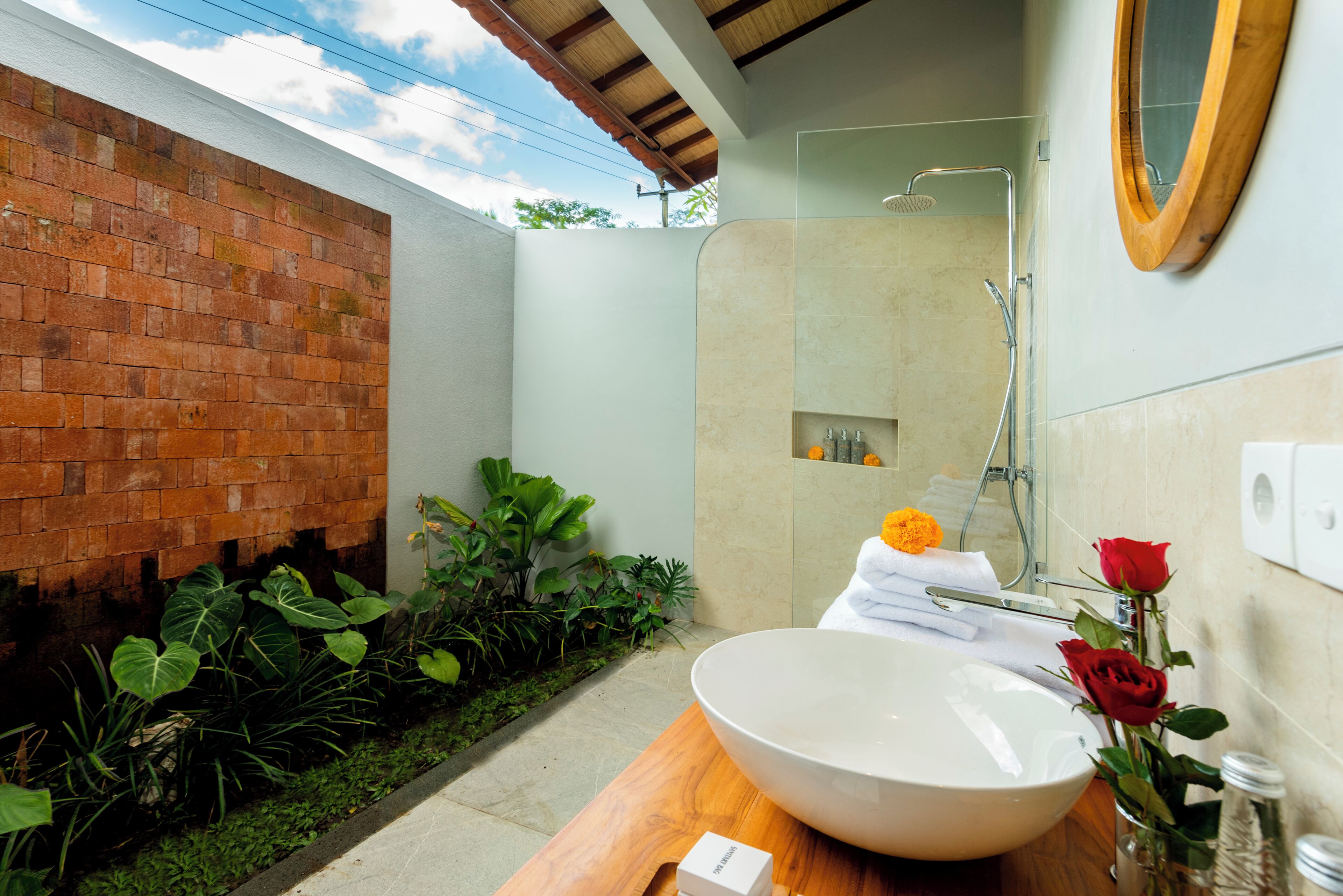 Un baño moderno con un lavamanos grande, ducha y espejo.