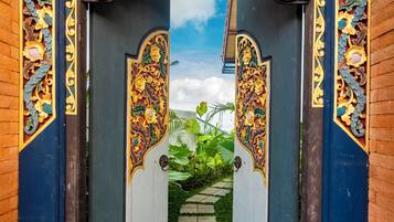 An ornate gate with intricate floral carvings, leading to a pathway.