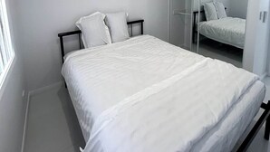 Un dormitorio con una cama, un armario y un espejo.