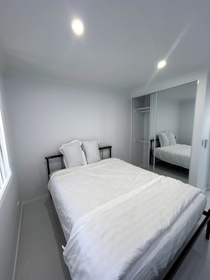 A bedroom with a bed, a wardrobe, and a mirror. - New 2BR1B Flat+2 Free parking|Lake nearby&Hospital (North Parramatta)