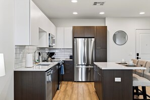 A modern kitchen with stainless steel appliances, a wooden countertop, and a built-in oven. - North Scottsdale Condo • Shared Rooftop Pool + Spa + Sauna + Views | Azur #246 (Phoenix)