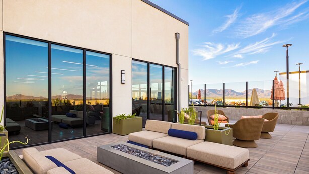 A modern outdoor seating area with a fire pit, sofas, and chairs, overlooking a desert landscape. - North Scottsdale Condo • Shared Rooftop Pool + Spa + Sauna + Views | Azur #246 (Phoenix)