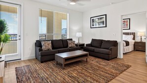 A modern living room with a sofa set, a coffee table, and a patterned rug. - Rooftop Pool + Sauna & Spa | Near TPC Golf + Preserve | Azur (Phoenix)