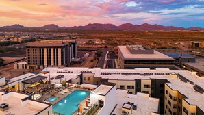 A rooftop pool area with a view of mountains in the distance. - Rooftop Pool + Sauna & Spa | Near TPC Golf + Preserve | Azur (Phoenix)