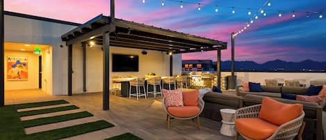 An outdoor patio area with a bar, seating, and a view of the mountains.
