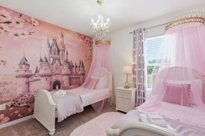 Ein Schlafzimmer mit zwei Betten, einer Wandmalerei eines Schlosses, einer Deckenleuchte und einem Fenster mit Vorhängen.