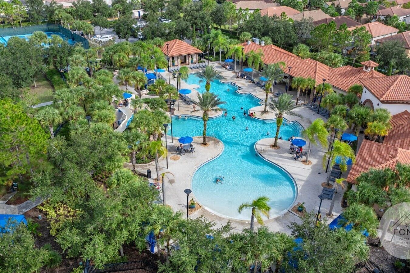 A resort with a large central pool, multiple smaller pools, and a variety of seating areas surrounded by palm trees.